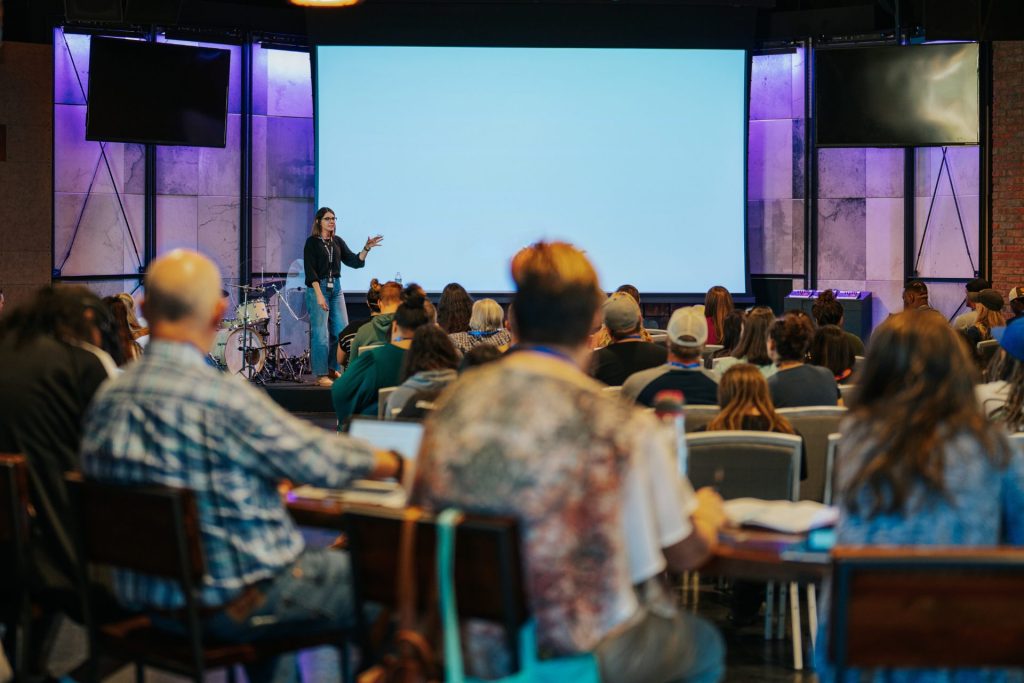 Woman teaching to a classroom of people.